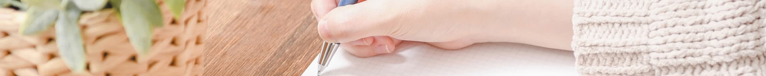 ノートにペンで書き込む手元