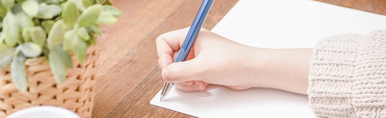 ノートにペンで書き込む手元